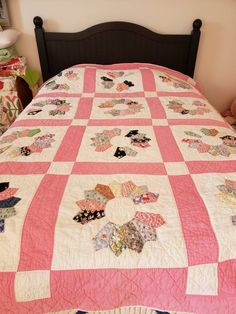 a bed with a pink and white quilt on it