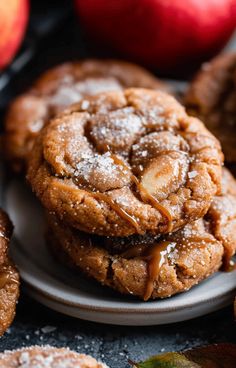 some cookies on a plate with apples in the background