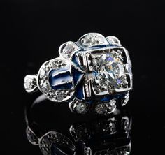 This vintage ring is crafted in solid 14K White Gold (carefully tested and guaranteed). The center Old European cut diamond is .75 carat of VS1 clarity and G color! It is accented with 18 mine cut diamonds of SI1-I1 clarity and H color totaling .38 carat. The blue enamel is in mint condition. The top of the ring measures 13mm top to bottom. The setting elevates 6mm high above finger. Size 4.5 (sizable). The ring weighs 4.2 grams. Great vintage condition. T5183455 Art Deco Enamel Rings For Formal Occasions, Formal Round Enamel Diamond Ring, Diamond Enamel Ring With Diamond Accents For Anniversary, Anniversary Jewelry With Diamond Accents And Enamel, Enamel Jewelry With Diamond Accents For Anniversary, Formal White Gold Enamel Ring, Classic Enamel Jewelry For Anniversary, Antique Blue Diamond Ring For Anniversary, Hallmarked White Gold Enamel Ring For Formal Occasions