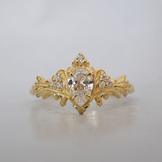 a gold ring with an oval shaped diamond surrounded by smaller round diamonds