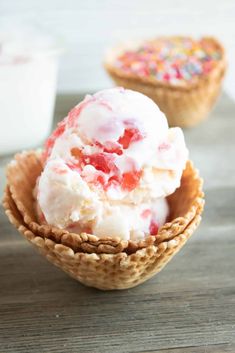 two cones filled with ice cream on top of a wooden table