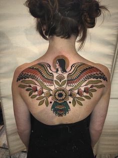 the back of a woman's upper body with tattoos on her chest and arms