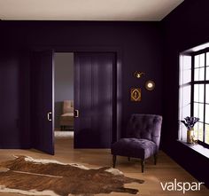 a room with purple walls and a cowhide rug on the floor in front of an open door