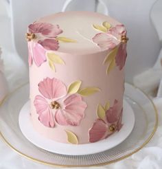 a pink cake decorated with flowers on a plate