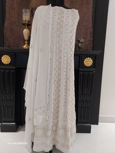 Beautifully handmade Pure Georgette- CHIKANKARI embroidered ANARKALI and DUPATTA Fabric (UNSTITCHED) with beautiful handcrafted with utmost elegance and precision, this piece is one of it's own.  The technique of creation of a chikan work is known as chikankari (चिकनकारी چکن کاری). Chikan is a delicate and artfully done hand embroidery on a variety of textile fabric like muslin, silk, chiffon, organza, net, etc. White thread is embroidered on cool, pastel shades of light muslin and cotton garments. Nowadays chikan embroidery is also done with coloured and silk threads in colours to meet the fashion trends and keep chikankari up-to-date. Lucknow is the heart of the chikankari industry today and the variety is known as Lucknawi chikan. Additional Information. Fabric: PURE GEORGETTE Colors: W White Anarkali Lawn Suit With Chikankari Embroidery, White Anarkali Lawn Suit For Eid, White Anarkali Lawn Suit For Festive Occasions, White Anarkali Salwar Kameez For Wedding, Festive White Anarkali Lawn Suit, White Anarkali Lawn Suit Unstitched, White Chikankari Embroidered Lawn Suit For Weddings, Bollywood Style White Georgette Sharara, Bollywood Style Off White Lawn Suit With Chikankari Embroidery