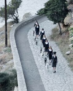 a group of women walking down a stone road