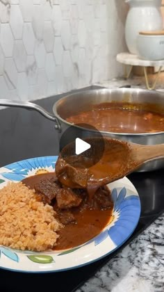 a plate with rice, meat and gravy on it