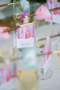 there are many wine glasses on the table with place cards in front of them,