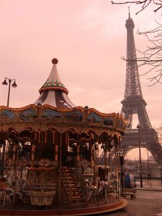 a merry go round in front of the eiffel tower