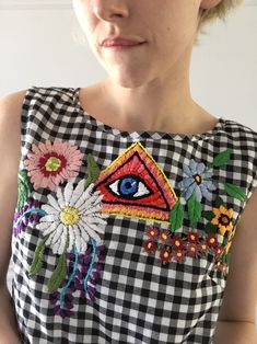 a woman wearing a black and white checkered dress with an eye patch on it