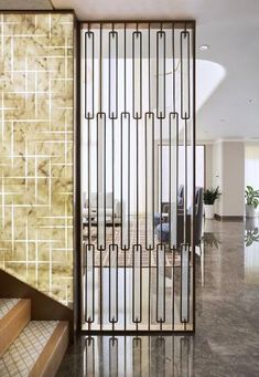 an open door leading to a living room and dining area with marble tile flooring