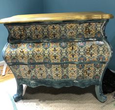 an ornate chest of drawers in a room