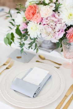 an image of a table setting with place settings and flowers in vases on it