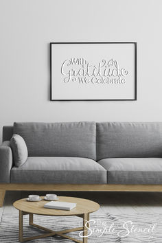 a living room with a gray couch and coffee table in front of the white wall