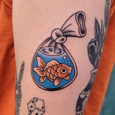 a woman with a tattoo on her arm has a goldfish in a fish bowl