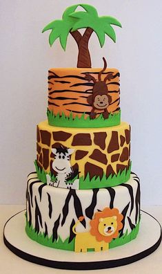 a three tiered cake decorated with animals and trees