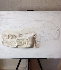 a drawing of a car on a piece of white paper next to a easel