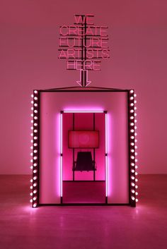 a pink room with neon lights and a chair