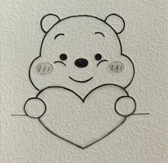 a drawing of a teddy bear holding a heart on a white wall with black outline