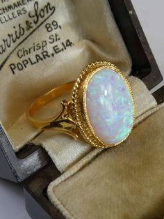 A fine silver with 18ct gold finish cutured opal ring. the opal has plenty of fire and is set in a simple rope twist mount . the front oval panel measures 1.6cm high x 1.3cm, ring size uk- o, usa 7.5. looks stunning when worn, uderstated but very classy. stamped 'sil' and has tested 925 silver and 18ct gold plated finish. Gold Ethiopian Opal Ring Hallmarked, Formal Hallmarked Oval Cabochon Opal Ring, Heirloom Oval Cabochon Opal Ring, Classic Gold Opal Oval Cabochon Ring, Formal Opal Oval Cabochon Ring, Classic Gold Opal Ring With Oval Cabochon, Hallmarked 14k Gold Opal Ring, Oval Shape, Classic Oval Hallmarked Opal Ring, Yellow Gold Opal Ring Oval Cabochon For Gift