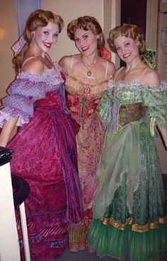 three women in dresses posing for the camera