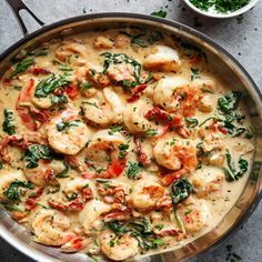 a pan filled with food sitting on top of a table next to a bowl and spoon