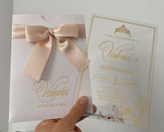 a person holding up a wedding card with a bow on it's front and back