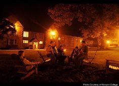 a group of people sitting on top of a park bench at night with their instruments