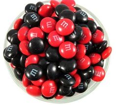 a bowl filled with black and red candies