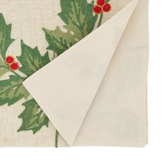 a napkin with holly leaves and red berries on it is folded to show the fabric