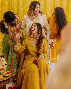 three women in yellow dresses laughing and having fun with each other at a wedding reception