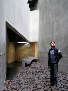 a man standing in front of a building with lots of coins on the ground next to him