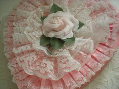 a pink and white flower on top of lace