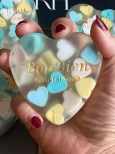 a person holding a heart shaped soap in their hand