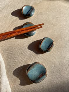 three blue bowls with chopsticks are on a tablecloth next to each other