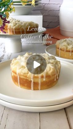 lemon coffee cake with vanilla glaze on a white plate next to flowers and vases