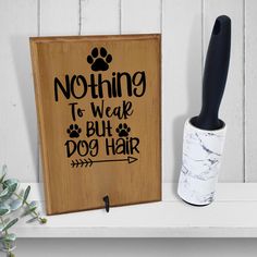 a wooden sign that says nothing to wear but dog hair next to a toothbrush holder