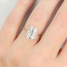 a woman's hand with a ring on it and a diamond in the middle