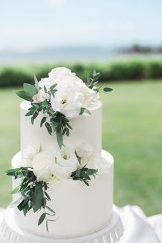 a wedding cake with white flowers and greenery