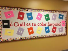 a colorful bulletin board with spanish words and pictures on it in an office building hallway