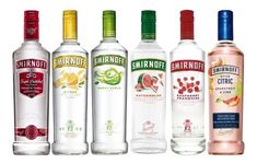 six bottles of different types of alcohol lined up in a row on a white background