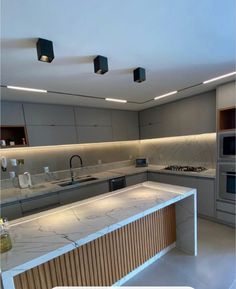 a large kitchen with an island counter and two lights on the ceiling over the stove