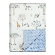 a baby blanket with giraffes and trees on it