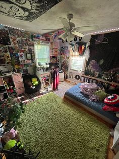 a bedroom with green carpet and walls covered in comic themed wallpapers, including a ceiling fan