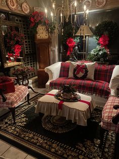 a living room decorated for christmas with red and white plaid furniture, poinsettis and wreaths