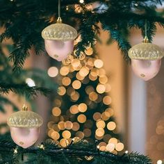 ornaments hanging from a christmas tree with lights in the background