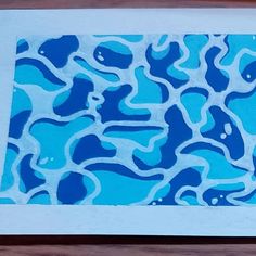 a blue and white abstract painting on wood