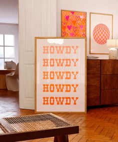 an orange and pink art piece is on display in the corner of a room with wood flooring