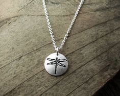 "A tiny dragonfly necklace made of pure silver. The dragonfly is symbolic in many cultures around the world and it represents prosperity, good luck, strength and harmony. I do a larger version of this design which you can see here: https://www.etsy.com/lulubugjewelry/listing/127418415/dragonfly-necklace-silver-dragonfly The pendant is approximately 3/8\" in diameter, or 10mm. Entirely hand made by me, starting with my original drawing. Then I make the stamping tool and create the piece. The pend Dainty Sterling Silver Dragonfly Jewelry, Dainty Silver Dragonfly Jewelry, Dragonfly Shaped Sterling Silver Jewelry Gift, Sterling Silver Dragonfly Jewelry Gift, Adjustable Dragonfly Necklace For Gifting, Adjustable Dragonfly Necklace For Gift, Spiritual Dragonfly Jewelry Gift, Adjustable Sterling Silver Dragonfly Necklace, Handmade Dragonfly Necklace For Gifting