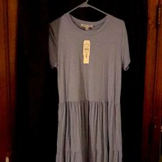 a dress hanging on a hanger in front of a door with an empty tag attached to it